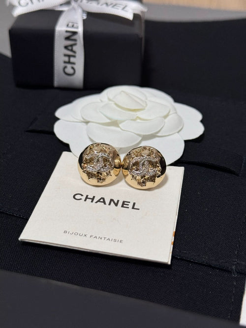 Gold-tone round stud earrings with crystal halo motif on a jewelry card