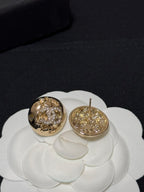 Gold-tone round stud earrings with crystal halo motif, one showing the post