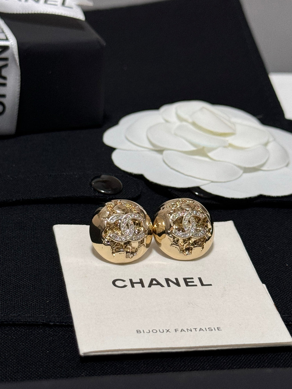 Gold-tone round stud earrings with glittering crystal design, shown from the front