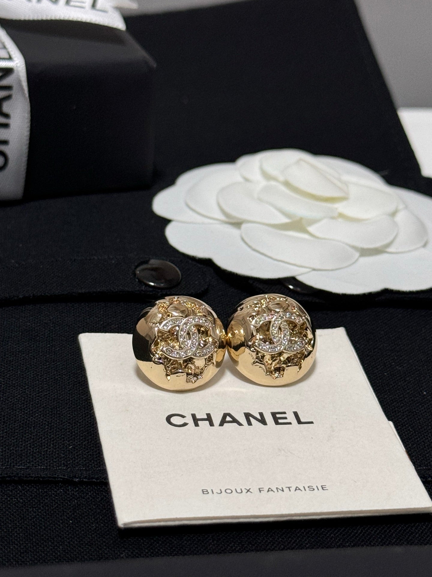 Gold-tone round stud earrings with glittering crystal design, shown from the front