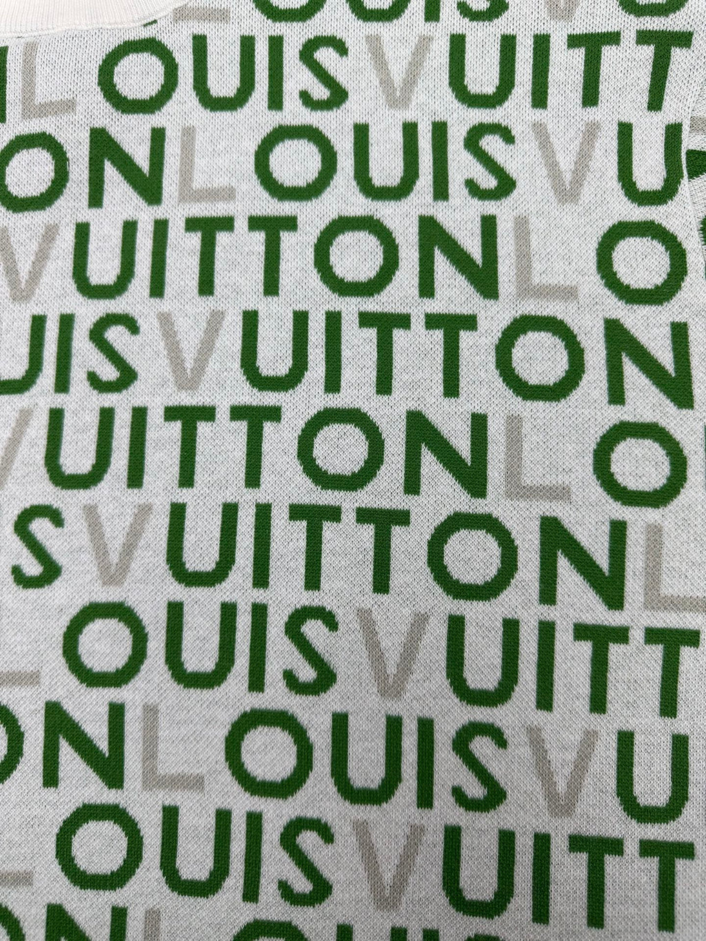 Green-and-white patterned fabric with repeating text-style logo