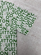 Folded sleeve area and cuff of green patterned top with white trim