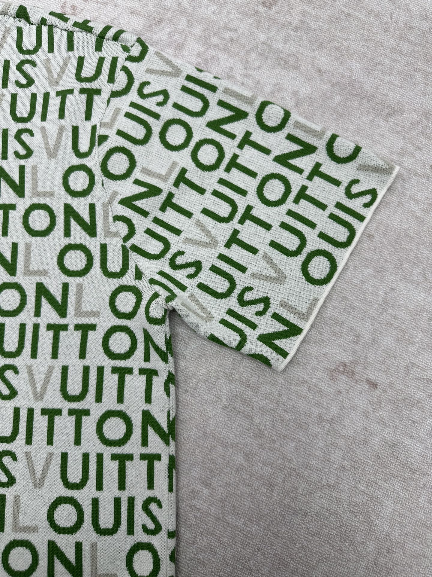 Folded sleeve area and cuff of green patterned top with white trim