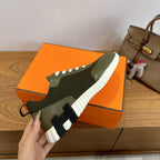 Unisex sneaker side view in olive green with white tread sole and black lace eyelets