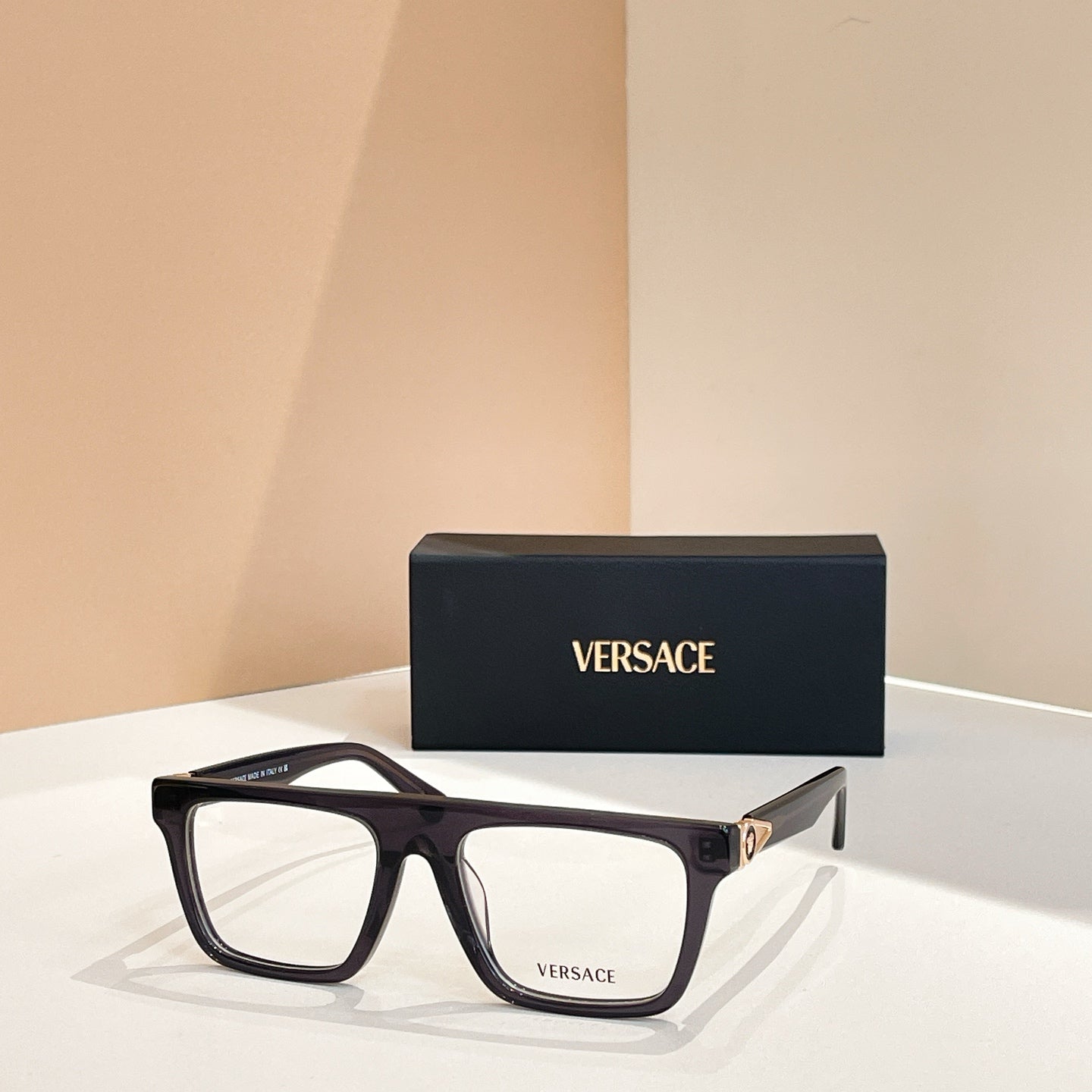 Versace eyeglasses with black rectangular frames, clear lenses, and gold accents.