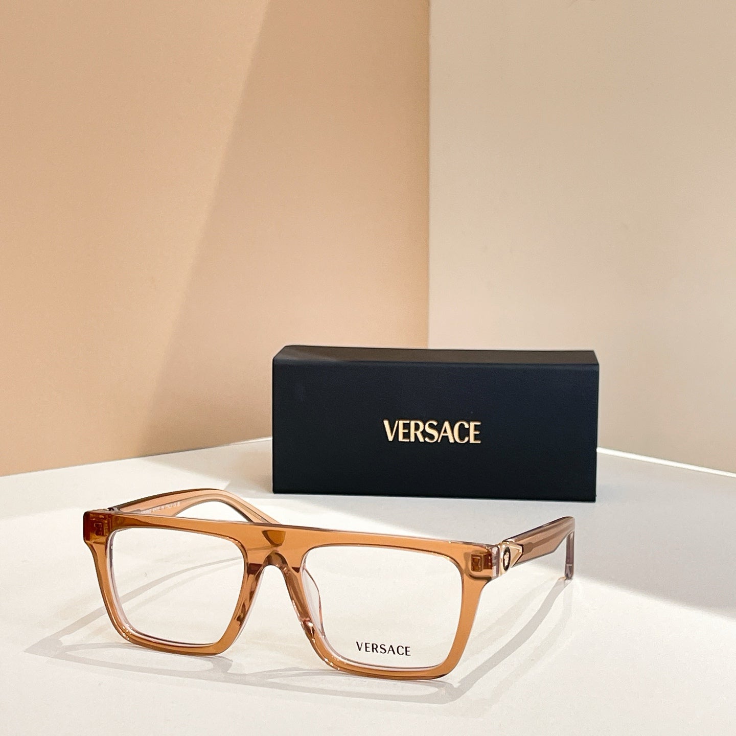 Versace eyeglasses with amber rectangular frames and gold temple details.