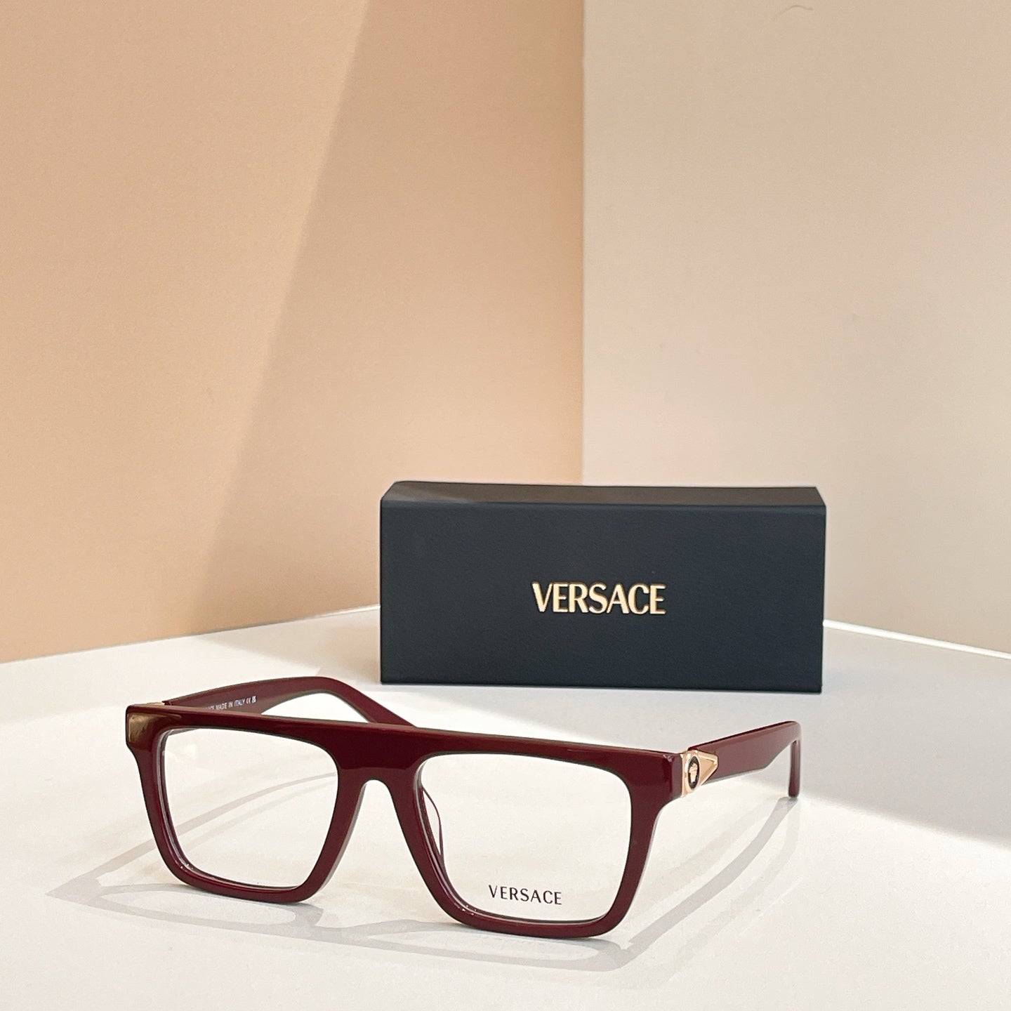Versace eyeglasses with dark red rectangular frames and gold temple hardware.