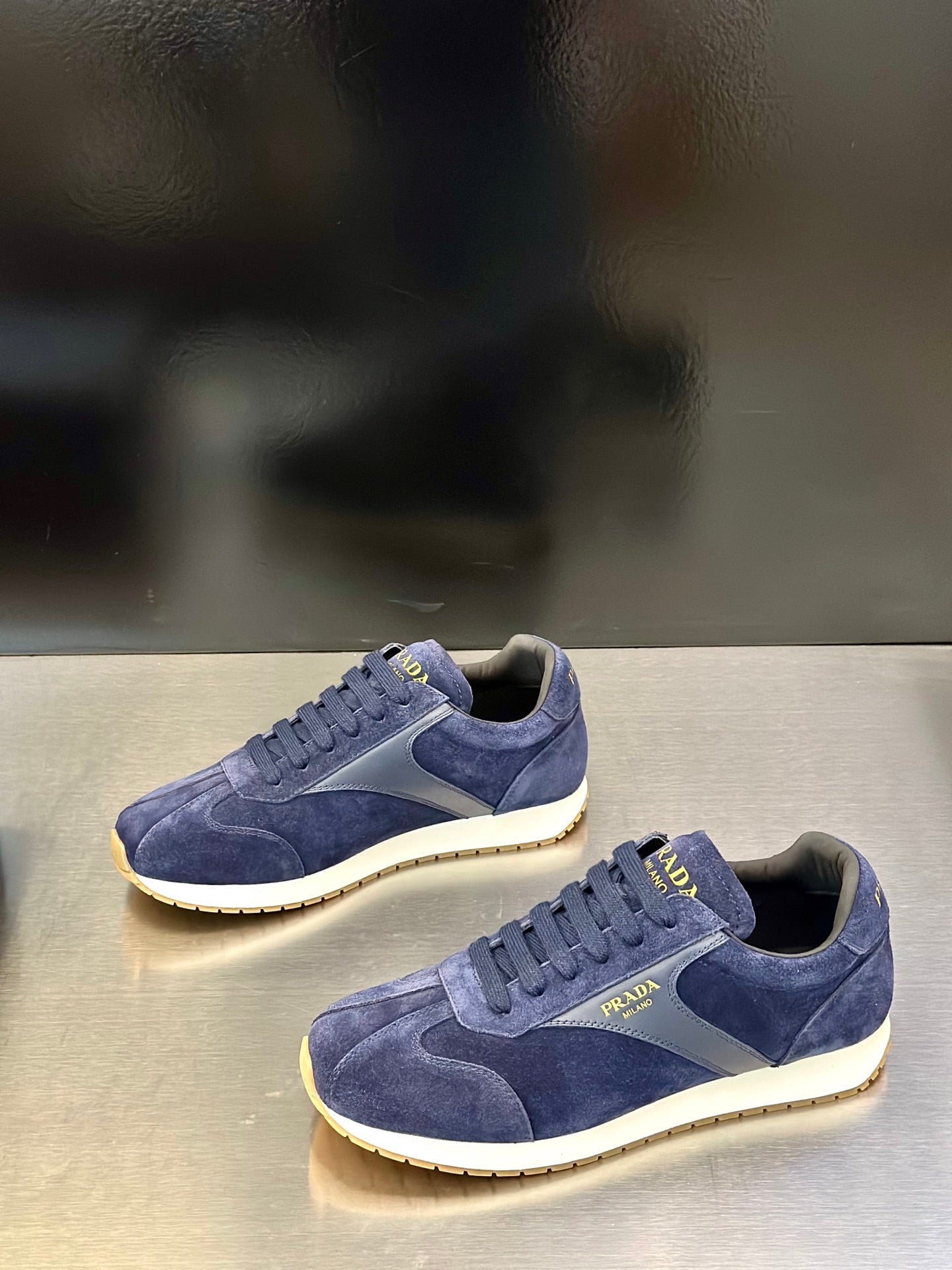 Prada unisex suede sneakers, blue, pair shown at an angle with cream soles and lace-ups.