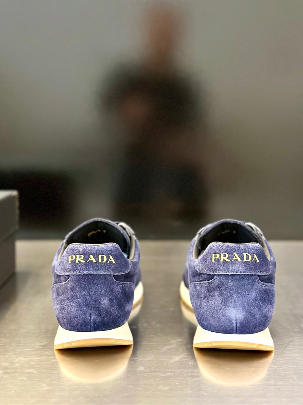 Prada unisex suede sneakers, blue backs with “PRADA” logo on the heel tabs.
