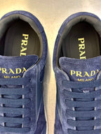 Prada unisex sneakers close-up of blue laces with “PRADA MILANO” text on inner tongue.