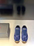 Prada unisex suede sneakers in blue, lace-up style with gold “PRADA” branding on tongue.
