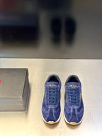 Prada unisex suede sneakers in blue, lace-up style with gold “PRADA” branding on tongue.