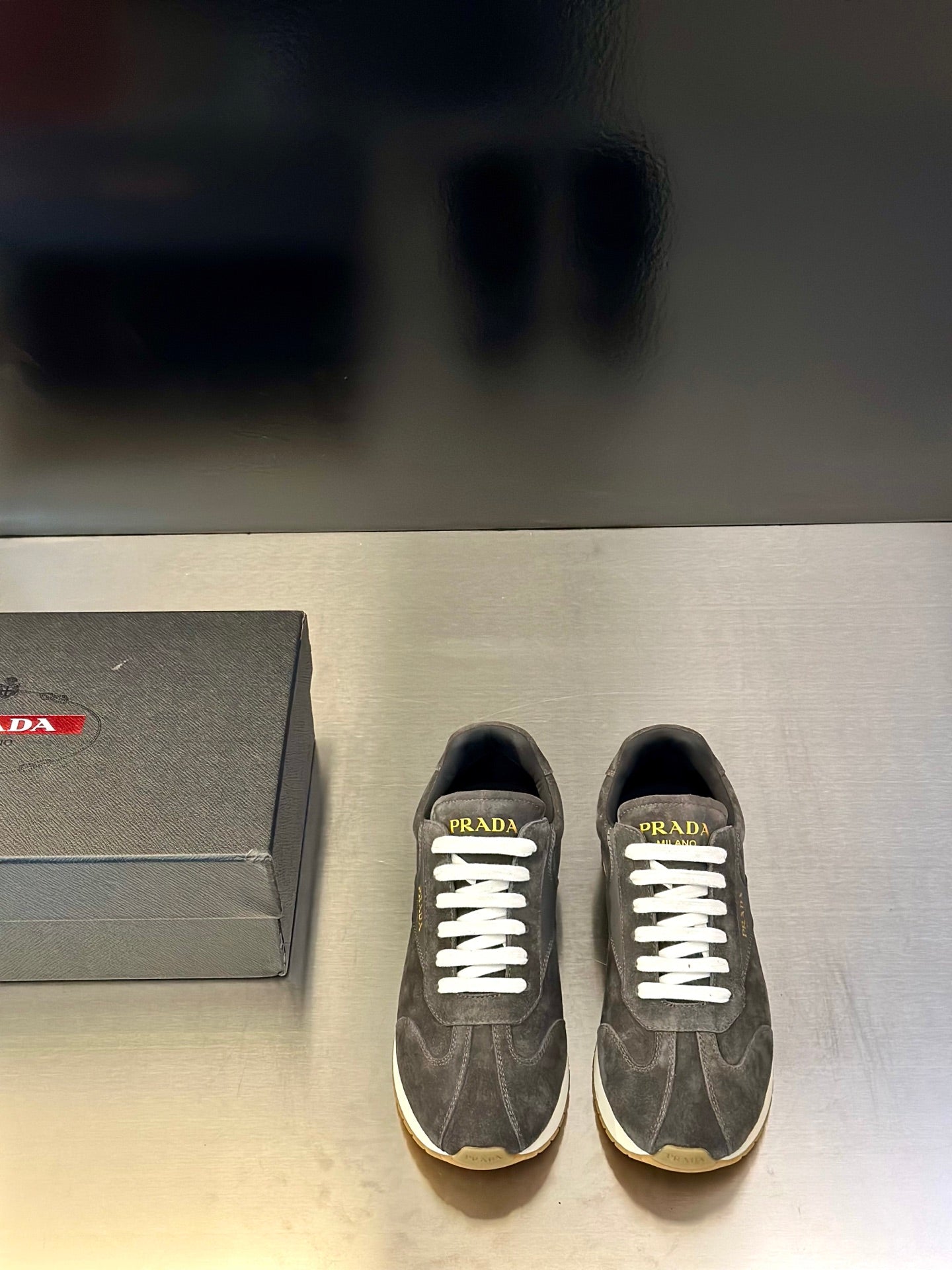 Prada unisex lace-up sneakers, dark gray suede with white laces and logo on tongue