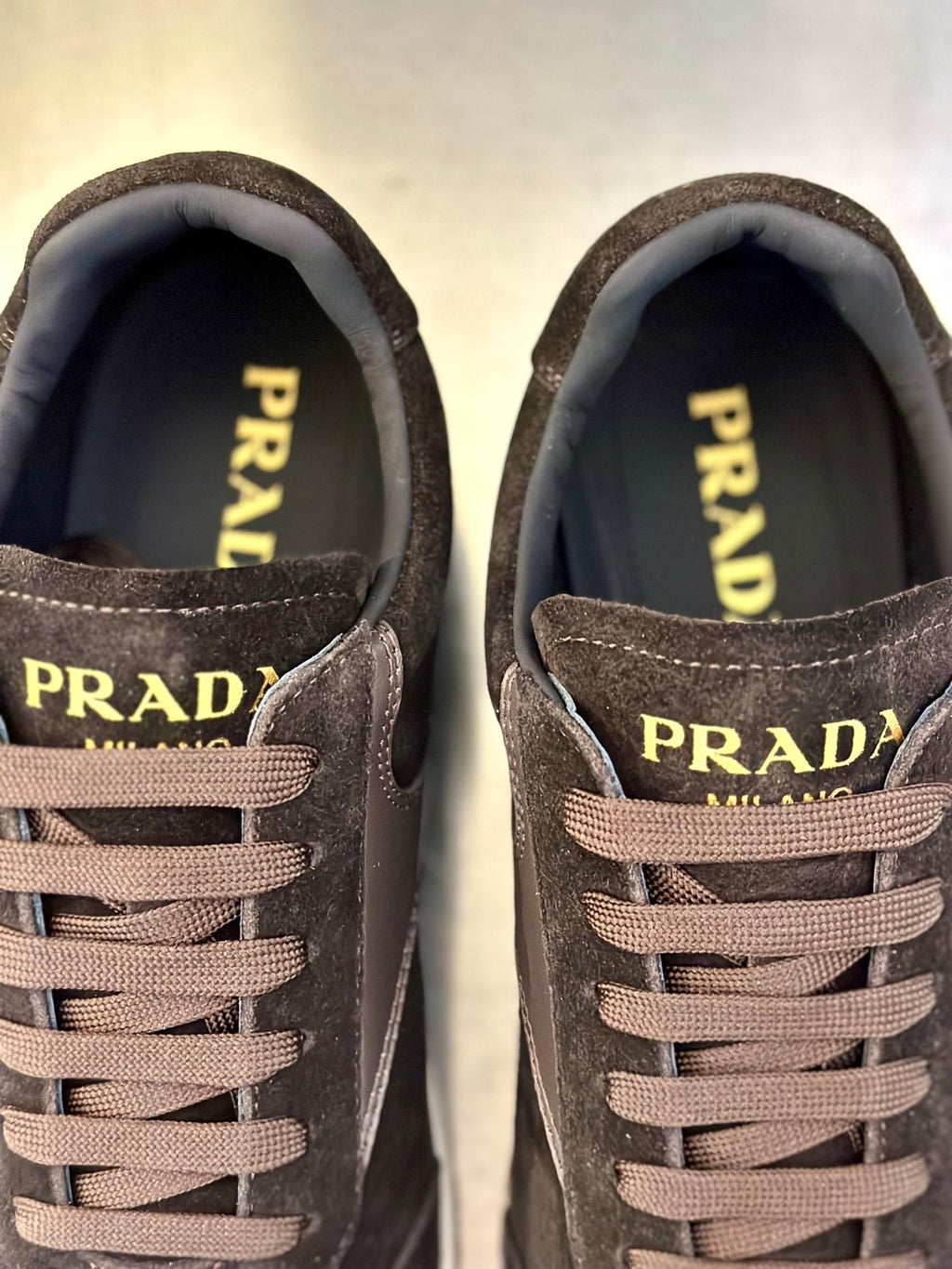 Prada unisex sneaker close-up: PRADA logo on tongues with lace-up front.
