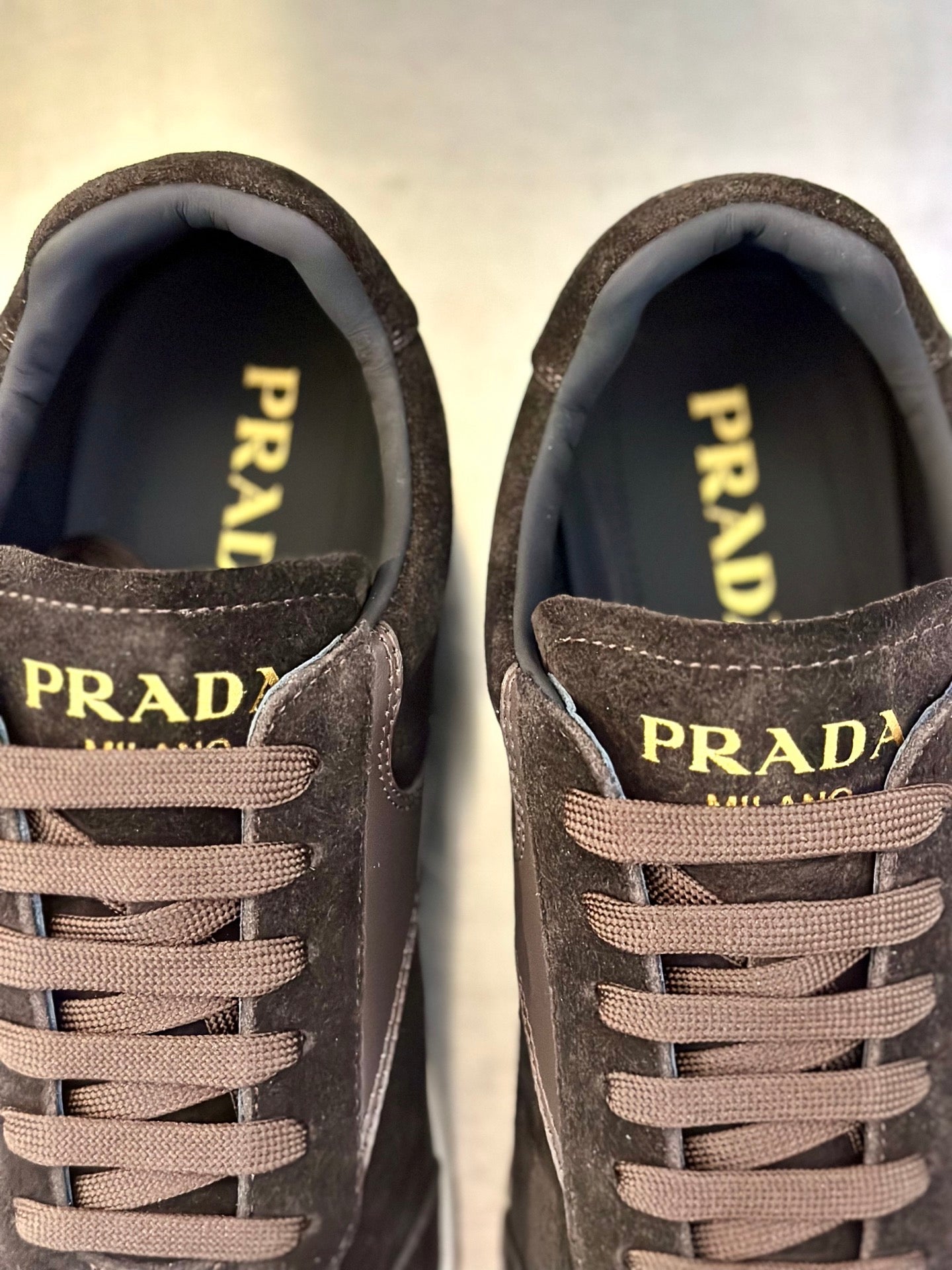 Prada unisex sneaker close-up: PRADA logo on tongues with lace-up front.