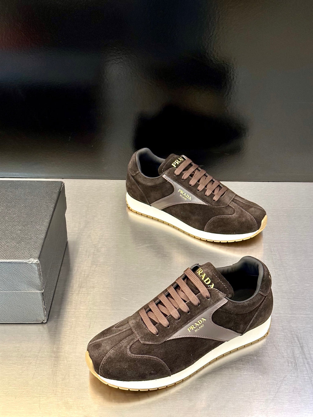 Prada unisex sneakers in dark brown suede with white sole and side logo panel.