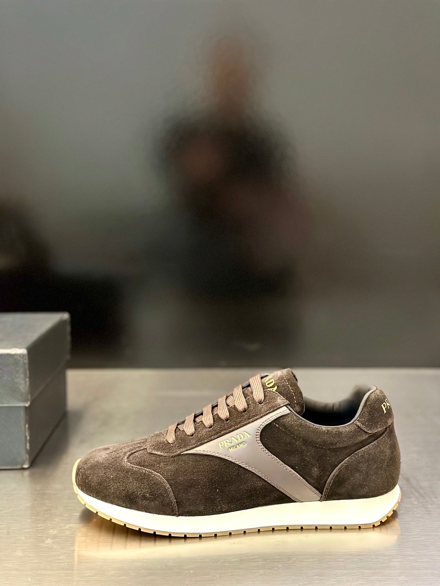 Prada unisex low-top sneakers with dark brown suede and off-white rubber sole.