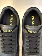 Prada logo close-up on dark leather sneaker tongue and lace panel