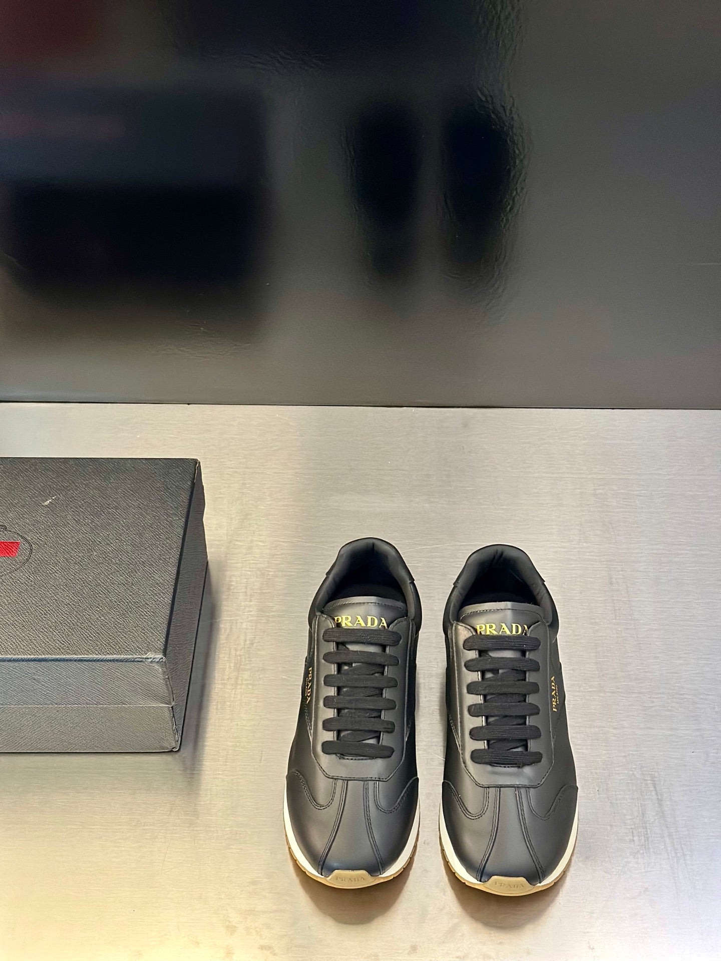 Prada leather lace-up sneaker in dark gray with side logo and light trim sole