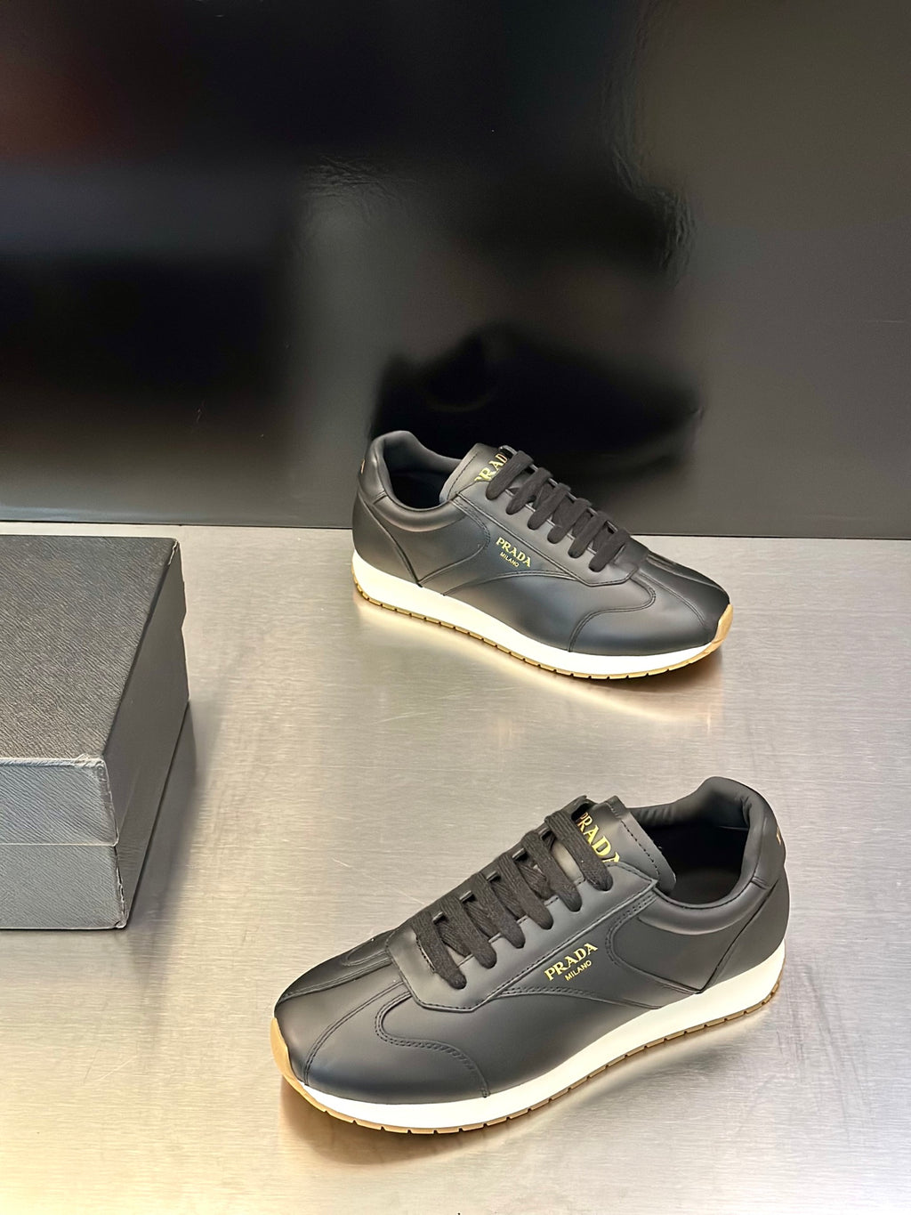 Prada leather lace-up sneaker in dark gray with side logo and light trim cupsole