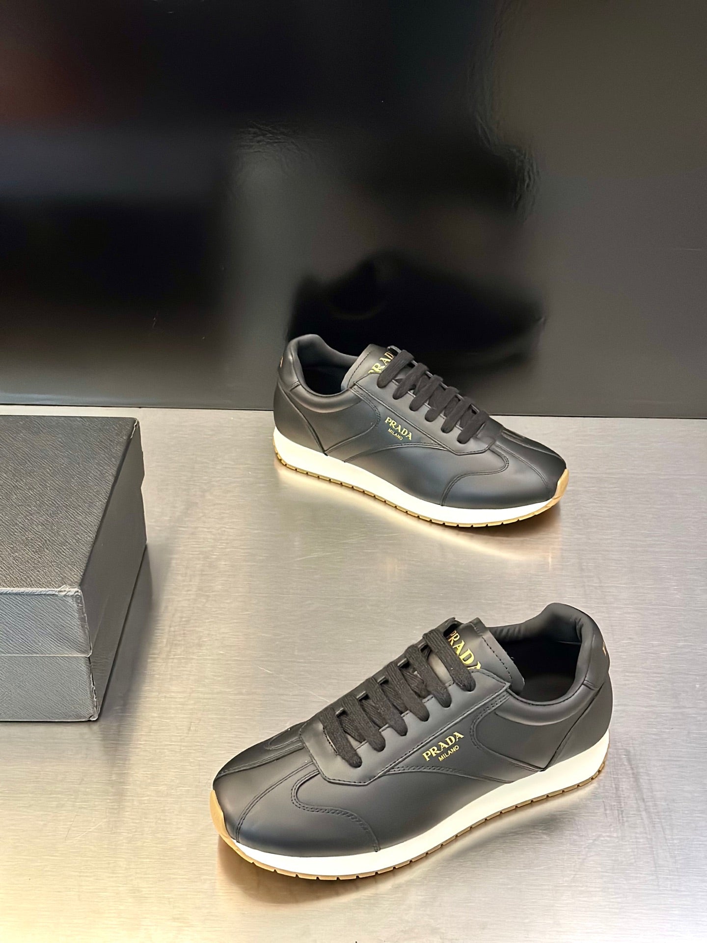 Prada leather lace-up sneaker in dark gray with side logo and light trim cupsole