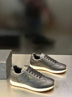 Prada leather lace-up sneakers in dark gray, side logo with textured rubber sole edge
