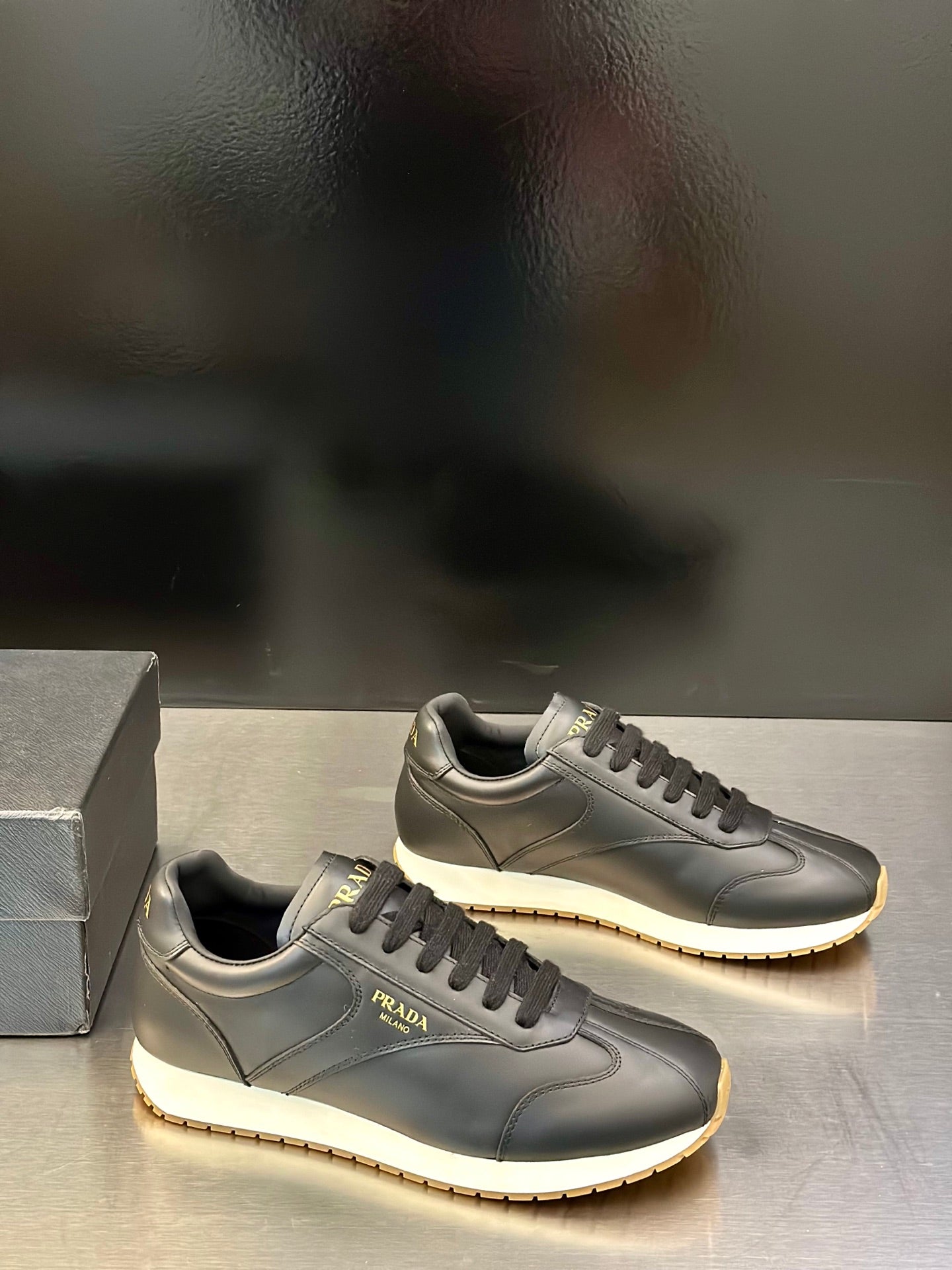 Prada leather lace-up sneakers in dark gray, side logo with textured rubber sole edge