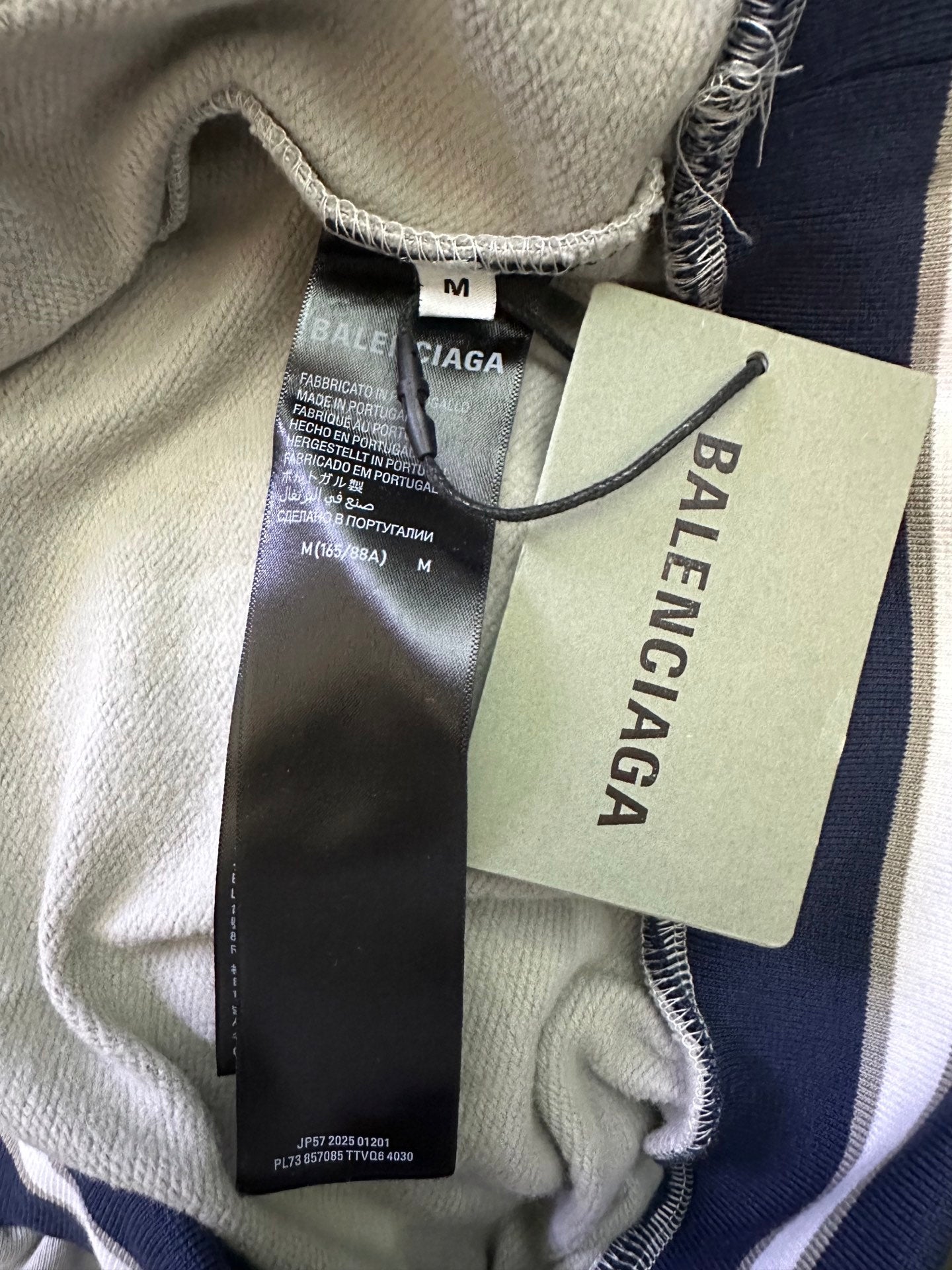 Light gray hoodie interior with size M tag and Balenciaga label near collar seam