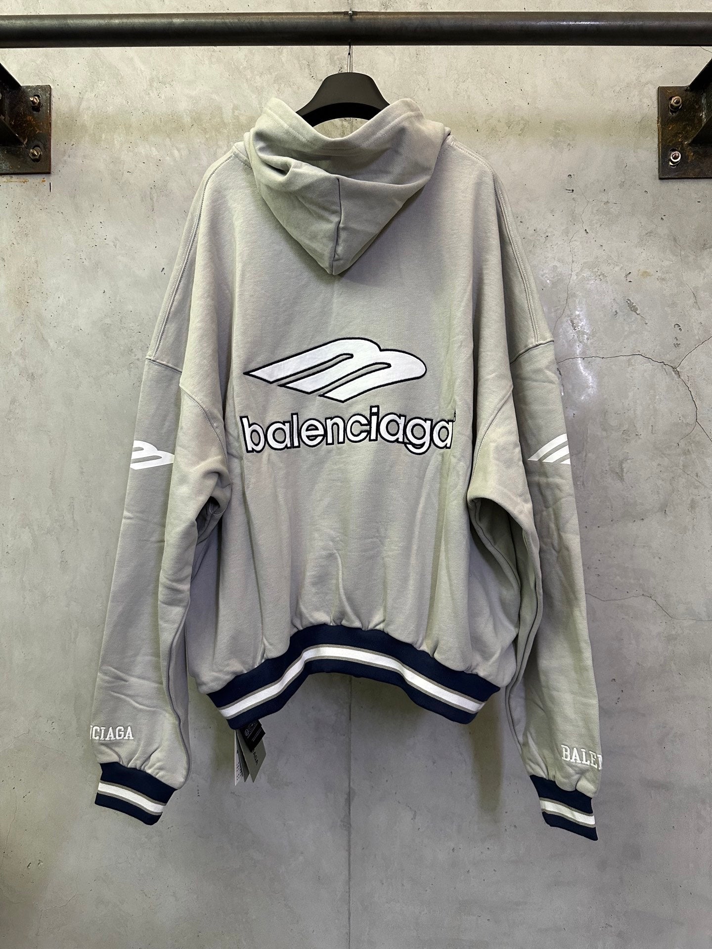 Light gray oversized hoodie with hood, large front Balenciaga logo, striped cuffs