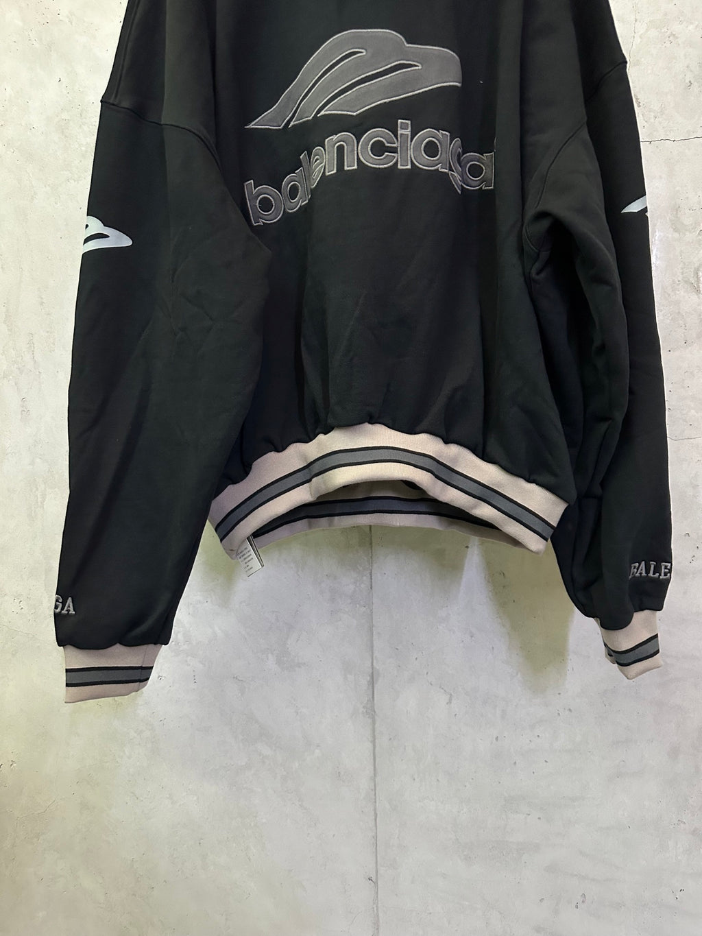 Black Balenciaga hoodie back view with logo print and striped cuff detail
