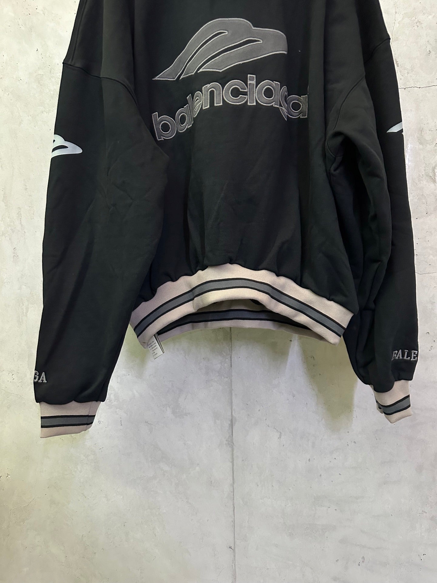 Black Balenciaga hoodie back view with logo print and striped cuff detail