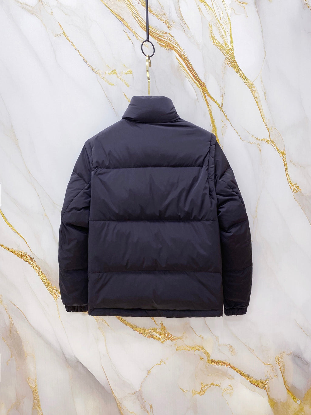 Gucci long puffer jacket in navy blue, back view with hood and horizontal quilting.