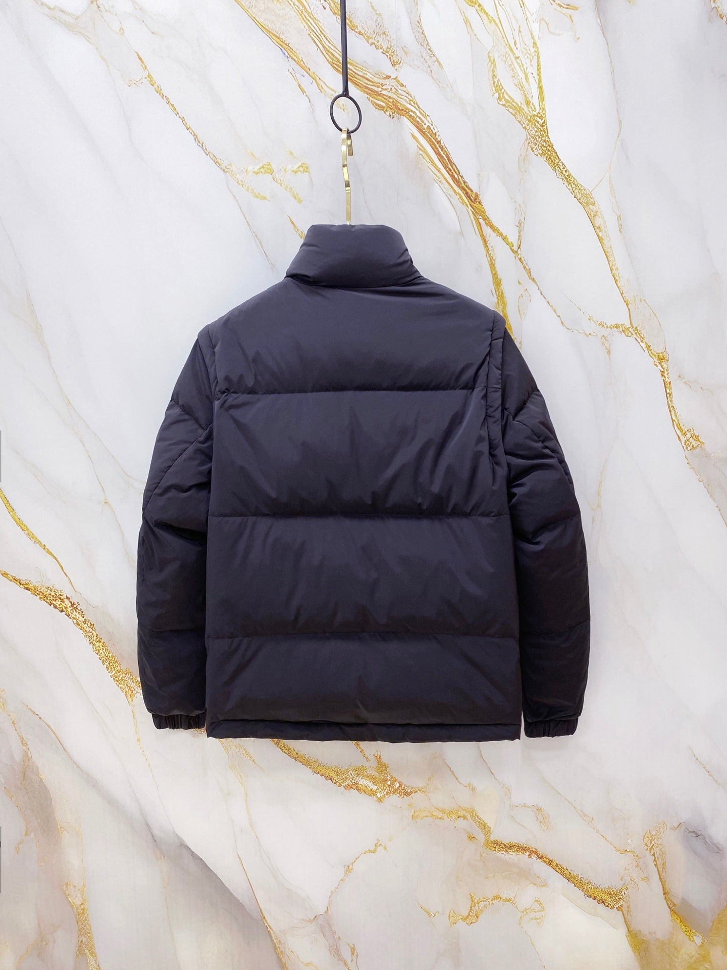 Gucci long puffer jacket in navy blue, back view with hood and horizontal quilting.