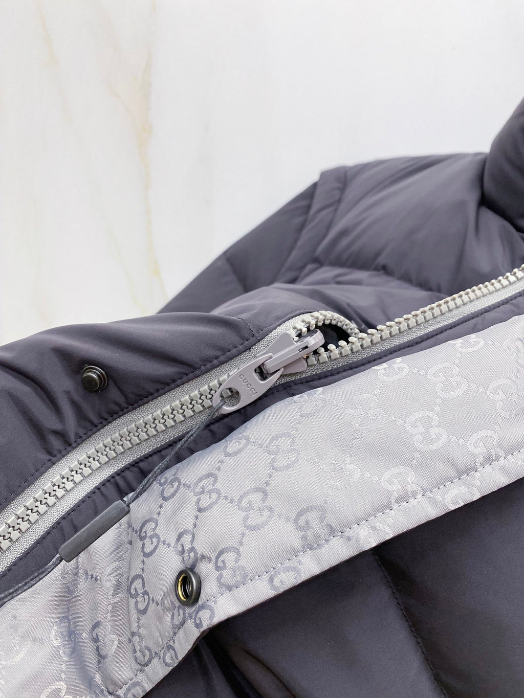 Dark gray puffer vest with silver zipper and patterned inner lining
