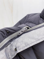 Dark gray puffer vest with silver zipper and patterned inner lining