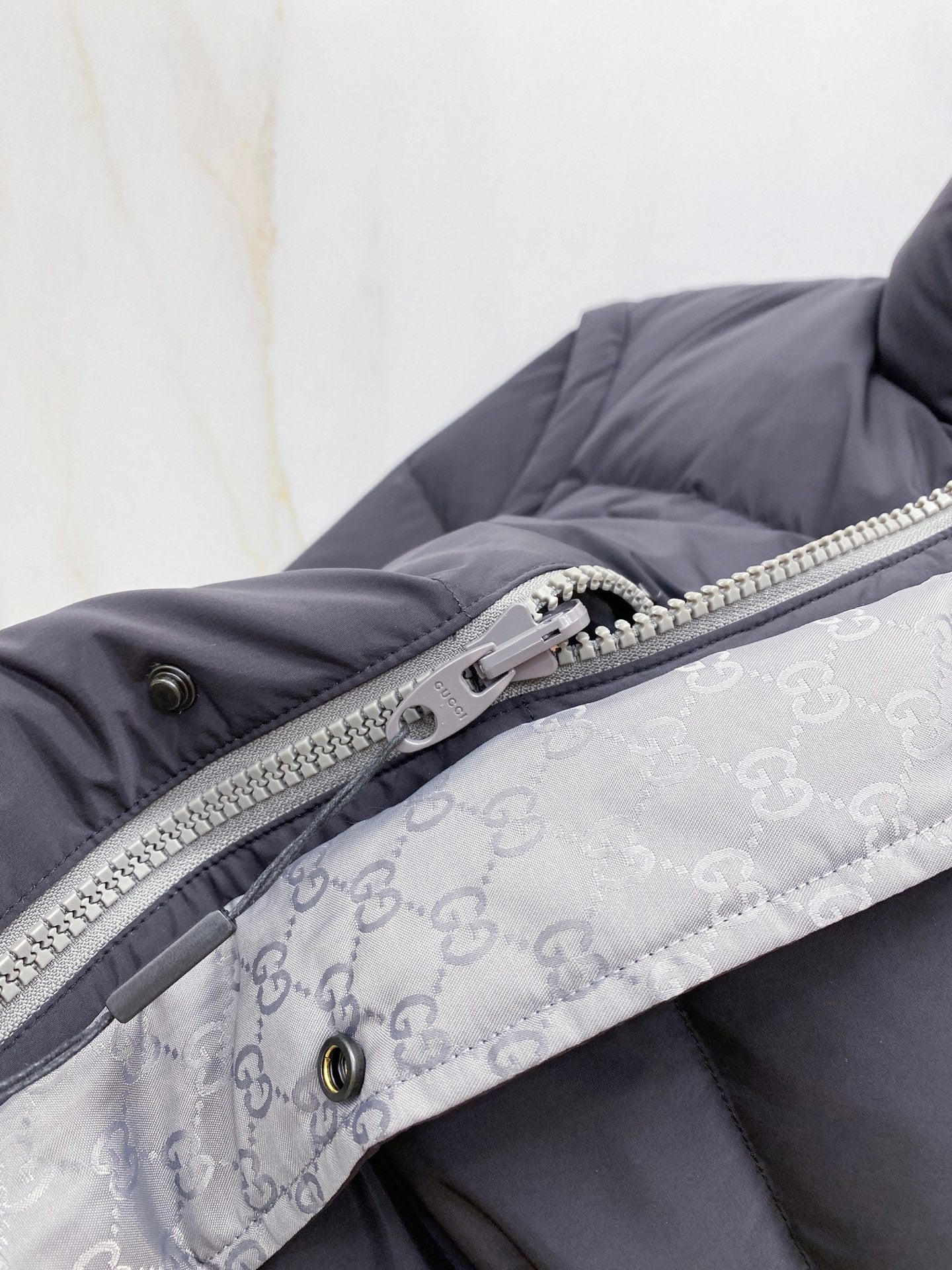Dark gray puffer vest with silver zipper and patterned inner lining