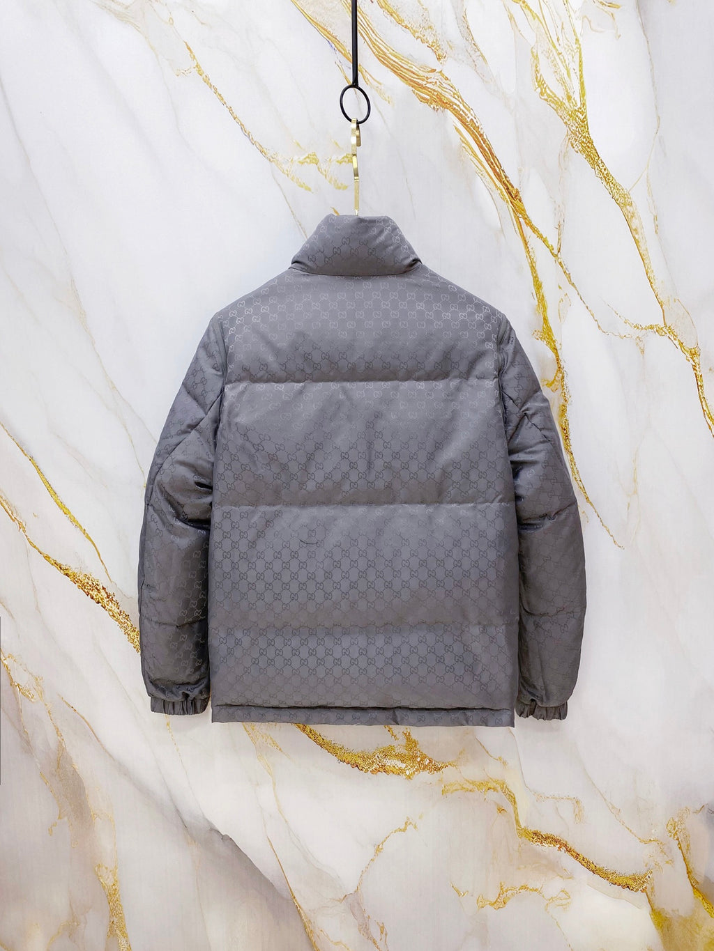 Gucci long puffer jacket in dark gray, back view with hood and horizontal quilting.