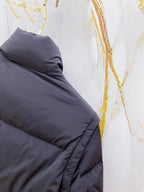 Dark gray puffer jacket sleeve with quilted padding and elastic cuff