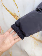Dark gray puffer vest cuff with elastic ruffle trim