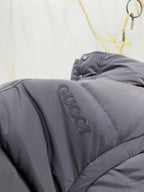 Dark gray puffer vest shoulder with embroidered Gucci logo