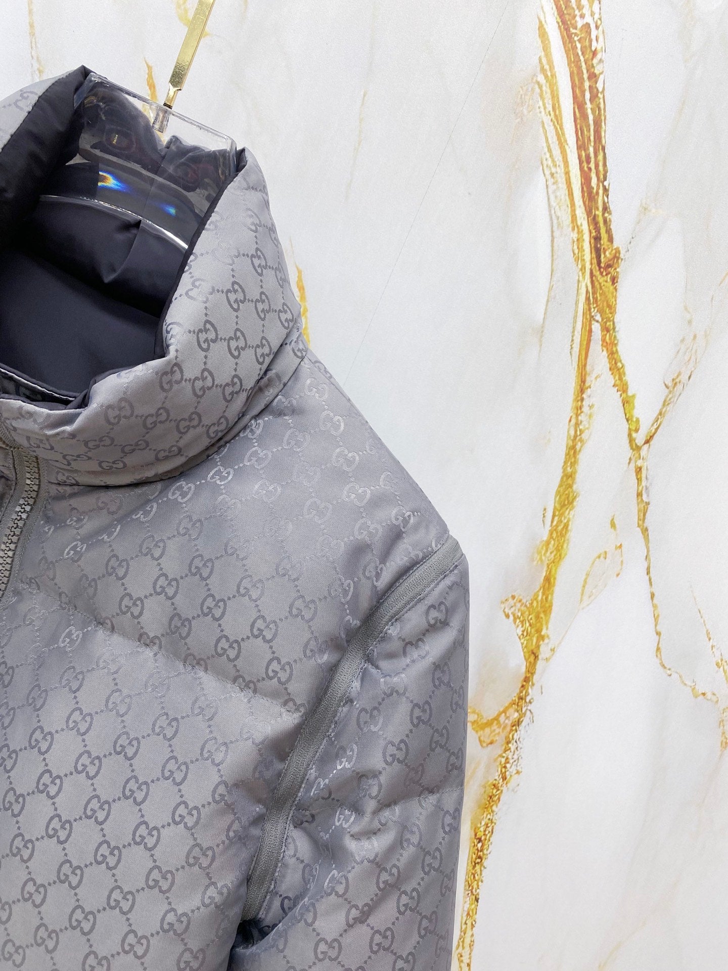 Gucci long puffer jacket torso in dark gray, allover GG pattern and front zip.