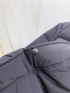 Dark gray puffer vest collar with snap button and stitched placket
