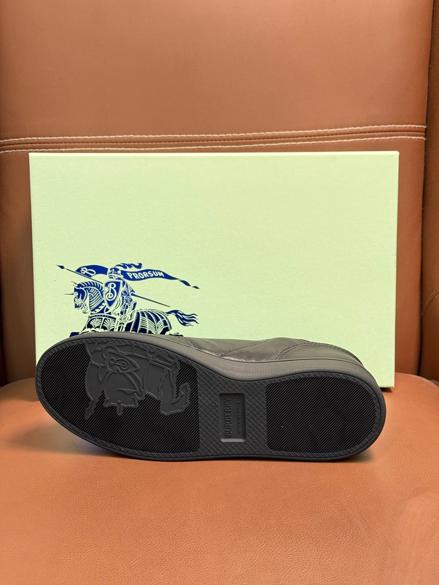 Dark leather sneaker outsole with traction tread, underside view