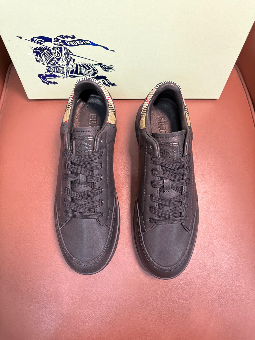Dark leather lace-up sneakers with black laces, shown as a pair