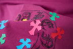 Purple T-shirt fabric with close-up multicolor cross and swirl logo graphic