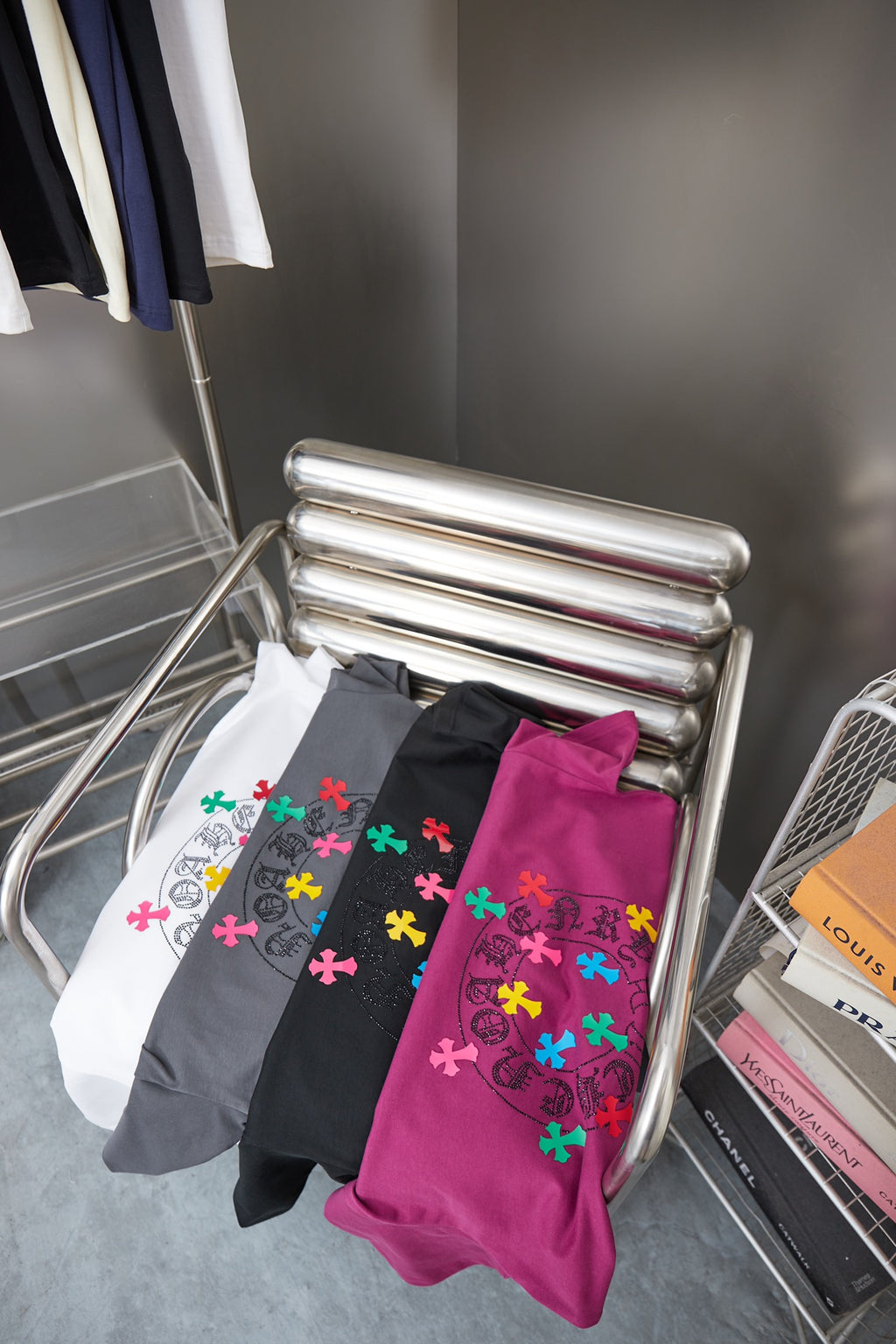 Assorted graphic short-sleeve T-shirts on rack, featuring dark gray and purple