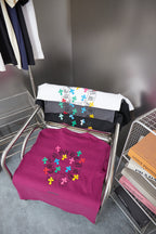 Stack of assorted color graphic short-sleeve T-shirts, including purple and white