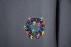 Gray T-shirt close-up of colorful cross emblem on chest