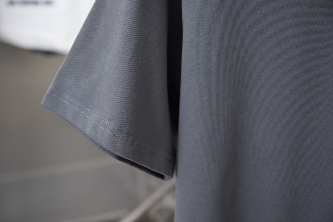 Gray T-shirt sleeve and hem with visible stitching detail