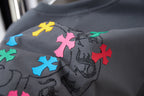 Gray T-shirt close-up of multicolor cross print with bead-like accents